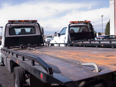 Two tow trucks side by side with empty trays at tow truck Ipswich